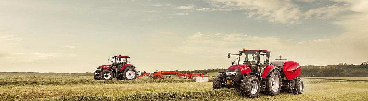 Two red tractors baling hay in a field 